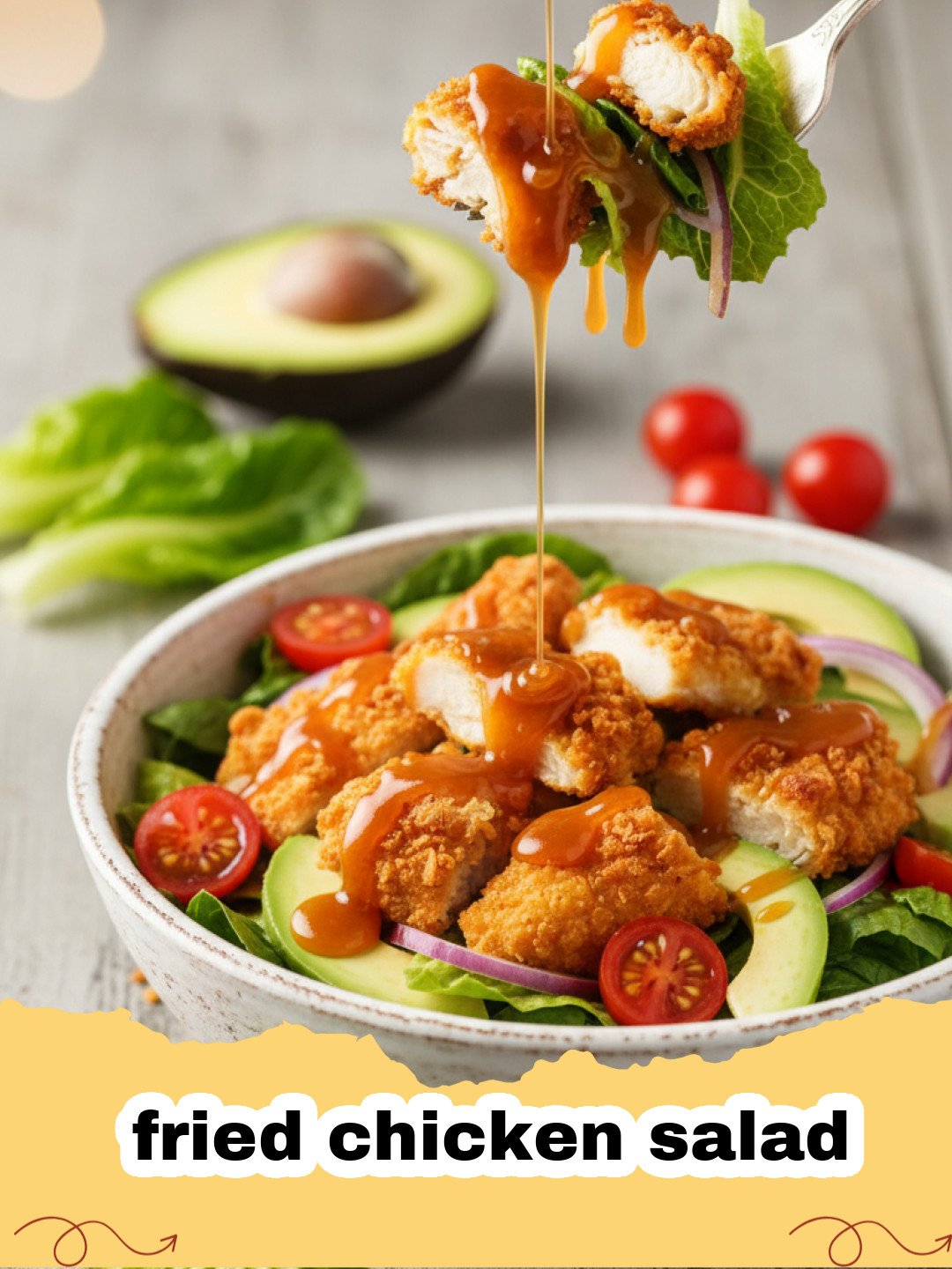A vibrant fried chicken salad topped with golden crispy chicken strips and honey mustard dressing