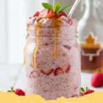 A glass jar filled with creamy strawberry overnight oats topped with fresh sliced strawberries.
