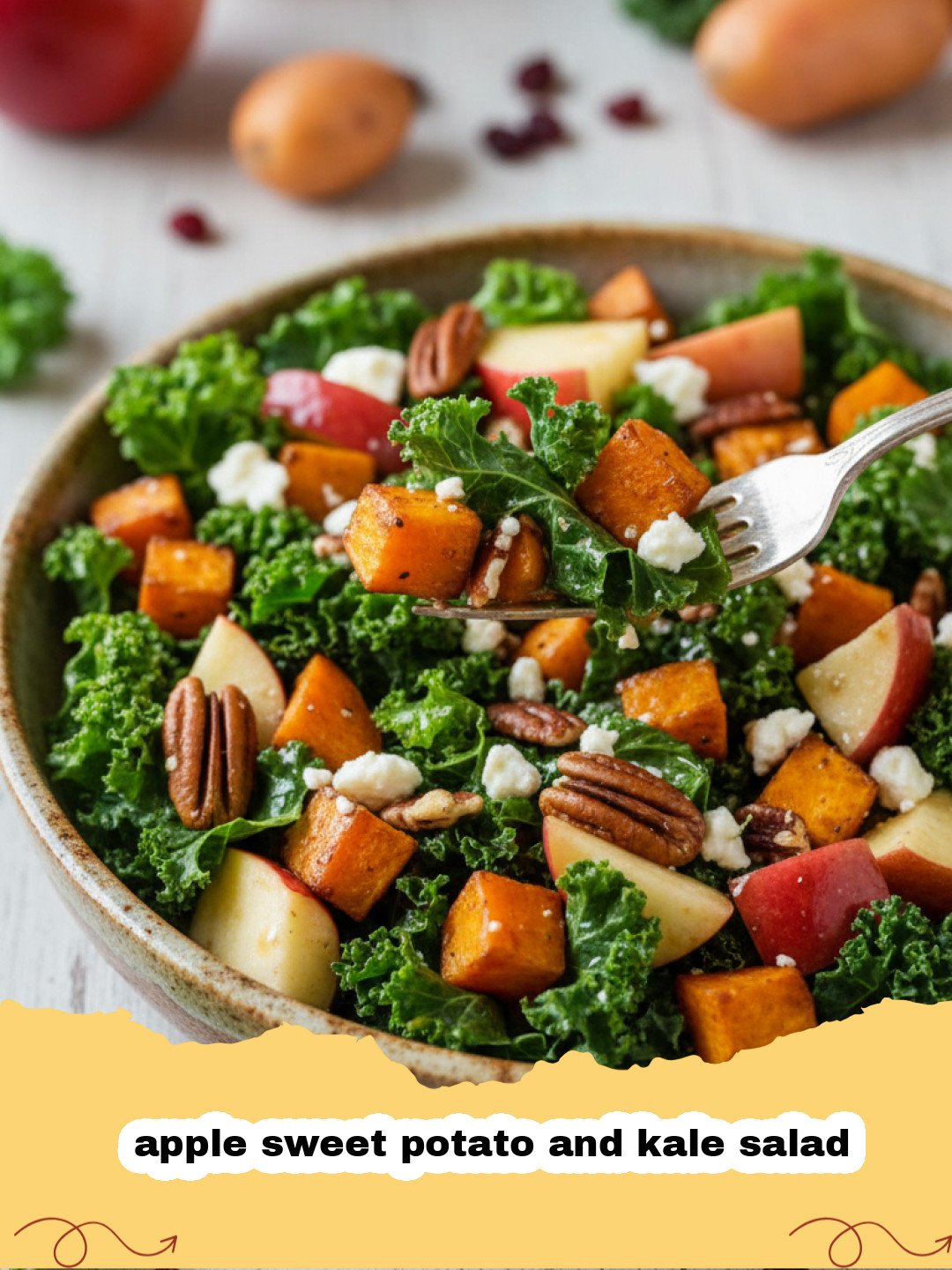 A close-up shot of an apple sweet potato and kale salad in a wooden bowl featuring vibrant orange potatoes and red apple slices.