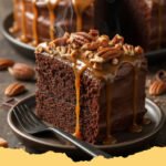 Turtle Texas Sheet Cake Recipe Fudge Caramel Pecans - A close-up shot of a square slice of Turtle Texas Sheet Cake, showing the rich chocolate cake, thick fudge frosting, generous pecan pieces, and a drizzle of caramel.