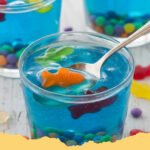 Edible Aquarium Jello Cups Recipe - Vibrant Edible Aquarium Jello Cups filled with gummy fish and blue jello, set against a light background.