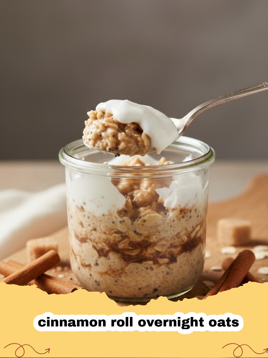 A jar of creamy cinnamon roll overnight oats with a swirl of cream cheese icing on top, garnished with a sprinkle of cinnamon.