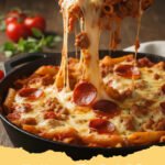 Close-up of a bubbling Meat Lovers Pizza Pasta Bake in a casserole dish, topped with melted mozzarella and pepperoni, ready to serve.