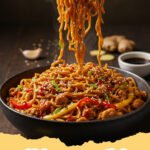 A close-up of a steaming bowl of chicken ramen stir fry with vibrant vegetables and tender chicken.