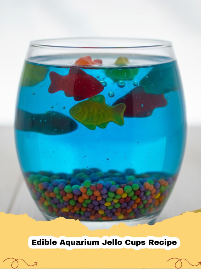 Edible Aquarium Jello Cups Recipe - Close-up of an Edible Aquarium Jello Cup filled with blue Jell-O, graham cracker 'sand', and colorful gummy sharks and fish.