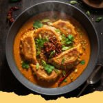 Easy Baked Potstickers Thai Curry Sauce - Crispy Baked Potstickers in a vibrant Thai Red Curry Sauce, garnished with fresh cilantro and a lime wedge.