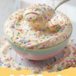 funfetti dip recipe - Close-up of a bowl of creamy funfetti dip with colorful sprinkles, surrounded by dippers like graham crackers and fresh fruit.