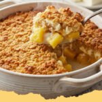 A golden-brown Easy Pineapple Cream Cheese Cobbler, fresh out of the oven, with a scoop of vanilla ice cream melting on top.