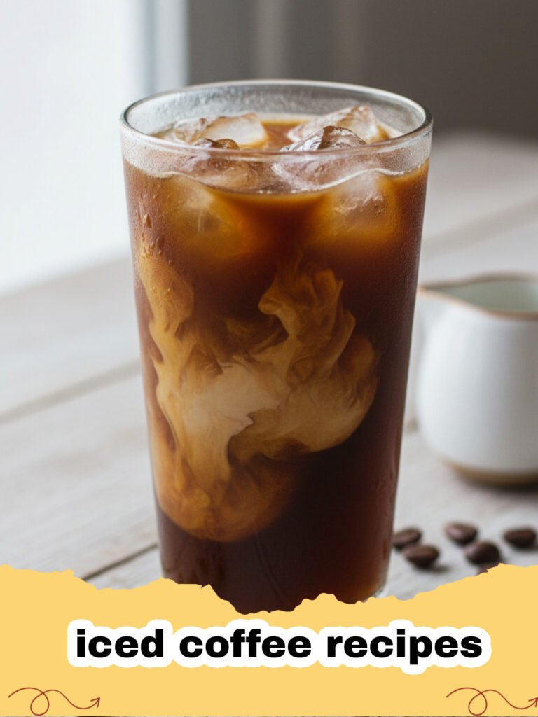 iced coffee recipes - A tall glass of homemade iced coffee with milk, ice, and a straw on a rustic wooden surface.