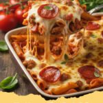 A close-up of a bubbling Meat Lovers Pizza Pasta Bake in a baking dish, topped with melted cheese and crispy pepperoni, with a serving spoon ready to dish out a portion.