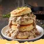 biscuits and gravy - A plate of warm, fluffy biscuits smothered in creamy white sausage gravy, ready to be eaten.