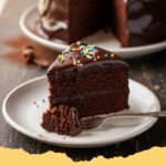Easy Moist Chocolate Cake Recipe - A beautifully frosted easy moist chocolate cake with a slice removed, revealing its tender, dark crumb.
