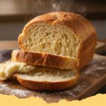 Freshly baked No Oven Stovetop Bread Recipe loaf on a cutting board, sliced, with steam rising from the interior.