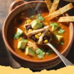 chicken tortilla soup recipe - A steaming bowl of homemade chicken tortilla soup with avocado, cilantro, and tortilla strips.