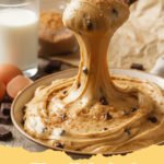 edible cookie dough recipe - A close-up shot of a bowl filled with classic chocolate chip edible cookie dough, with a spoon dipped in, ready to be eaten.