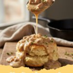 biscuits and gravy recipe - Fluffy buttermilk biscuits smothered in creamy, savory sausage gravy on a white plate, garnished with fresh parsley.