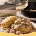 biscuits and gravy recipe - Classic Southern biscuits and gravy on a plate, featuring fluffy biscuits smothered in creamy, savory sausage gravy.