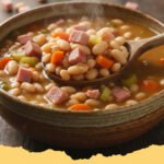 ham and beans crockpot recipes - A hearty bowl of ham and beans with crusty bread, garnished with fresh parsley.