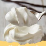 whipped cream recipe - Close-up of a bowl of fluffy homemade whipped cream with a whisk, garnished with a single strawberry