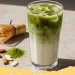 iced matcha latte recipe - A vibrant green iced matcha latte in a clear glass with ice, showing distinct layers of milk and matcha, garnished with a bamboo whisk and matcha powder on the side.