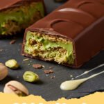 Dubai chocolate recipe - Close-up of a cracked Dubai chocolate bar revealing green pistachio cream and crunchy knafeh inside
