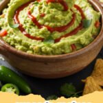 avocado recipes - Close-up of a vibrant avocado and black bean salad in a white bowl, garnished with fresh cilantro.