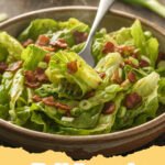 wilted lettuce recipe - A bowl of fresh wilted lettuce with crispy bacon bits and a warm, tangy dressing.
