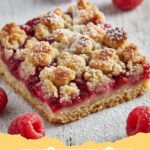raspberry recipes - Close-up of golden brown raspberry crumble bars in a baking pan, showing the vibrant red filling and crumbly topping.