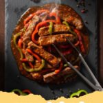 pepper steak recipe - A steaming plate of savory pepper steak with colorful bell peppers and tender beef strips over white rice.