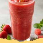 watermelon smoothie recipe - A bright pink watermelon smoothie in a tall glass with a lime slice and mint garnish