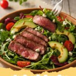 steak salad recipe - A beautifully arranged grilled steak salad with vibrant greens, cherry tomatoes, and sliced steak, drizzled with vinaigrette.