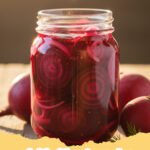 pickled beets recipe - Jars of vibrant red pickled beets on a wooden table with fresh beets in the background.