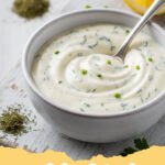 ranch dressing recipe - A close-up shot of creamy homemade ranch dressing in a glass jar surrounded by fresh herbs.