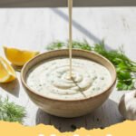 ranch dressing recipe - A bowl of creamy homemade ranch dressing garnished with fresh dill and chives, surrounded by fresh vegetables.