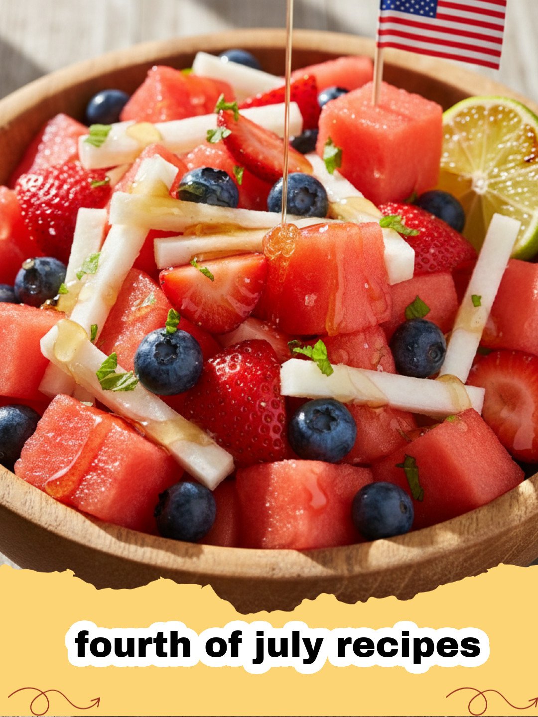 fourth of july recipes - Patriotic Berry and Feta Salad with Honey-Lime Dressing in a glass bowl on a wooden table, garnished with fresh mint, perfect for Fourth of July.