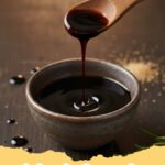balsamic glaze recipe - A small bowl of glossy, dark balsamic glaze next to a bottle of balsamic vinegar, ready for drizzling.