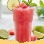 watermelon slushie recipe - Close-up of a vibrant red watermelon slushie in a glass with a lime wedge garnish.