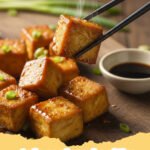 tofu recipes healthy - Close-up of Savory Sesame Garlic Tofu Stir-Fry with broccoli, bell peppers, and mushrooms, garnished with sesame seeds and green onions, served over rice in a white bowl.