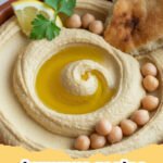 A creamy, homemade classic hummus recipe drizzled with olive oil and sprinkled with paprika, served with pita bread and fresh vegetables.