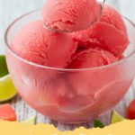watermelon sorbet recipe - Bright pink watermelon sorbet in a glass bowl with a scoop, garnished with fresh mint and a lime wedge.