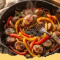 sausage and peppers recipe - Close-up of a skillet filled with juicy Italian sausage, colorful bell peppers, and onions in a rich tomato sauce, ready to be served.