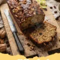 zucchini bread recipe - Two golden-brown loaves of classic moist zucchini bread on a cooling rack, with a sliced piece showing the tender crumb.