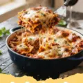 A bubbling, cheesy lazy lasagna recipe fresh from the oven, garnished with fresh parsley.