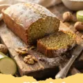 zucchini bread recipes - A perfectly baked loaf of moist zucchini bread on a wooden cutting board, with a few slices cut and ready to serve.