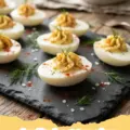 deviled egg recipe - A platter of perfectly piped deviled eggs garnished with paprika and chives.