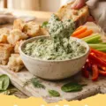 knorr spinach dip recipe - A classic Knorr spinach dip served in a rustic bowl with various dippers like pumpernickel bread, carrots, and celery.