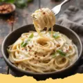 Creamy Smooth Cottage Cheese Pasta Sauce tossed with fusilli pasta, garnished with fresh basil and Parmesan cheese.