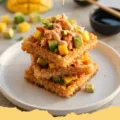 Golden brown Waffle Maker Crispy Rice Toppers, perfectly waffled and ready for toppings, on a wire rack with chopsticks.