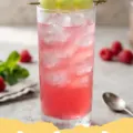 honey deuce recipe - A vibrant green Honey Deuce cocktail in a tall glass, garnished with three honeydew melon balls on a skewer and fresh raspberries.