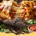 Cheesy Beef Pockets - Golden brown cheesy beef pockets on a baking sheet, with one cut open to show the melted cheese and beef filling.